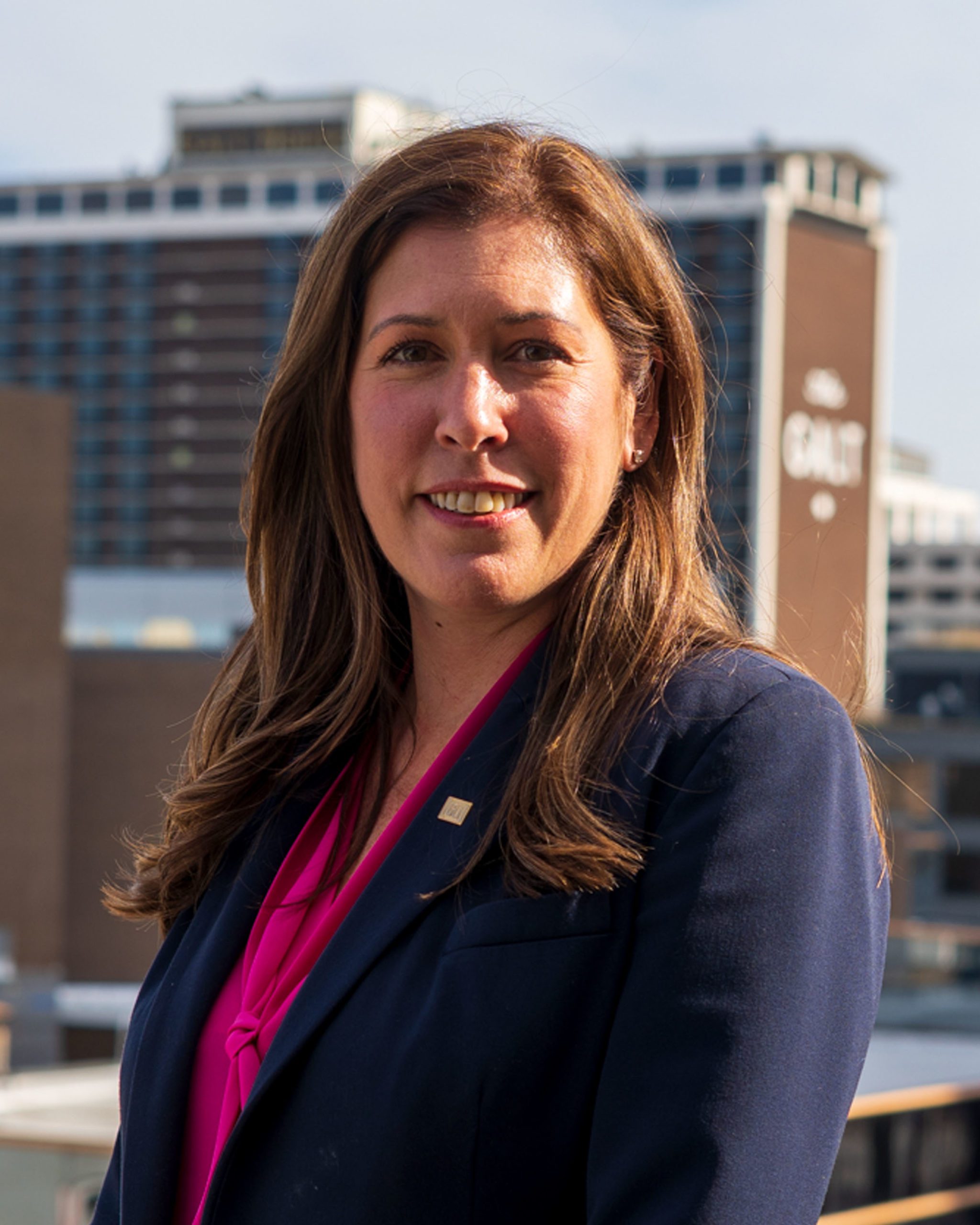 Headshot of Christine Tarquinio wearing a blue suit jacket and red shirt.