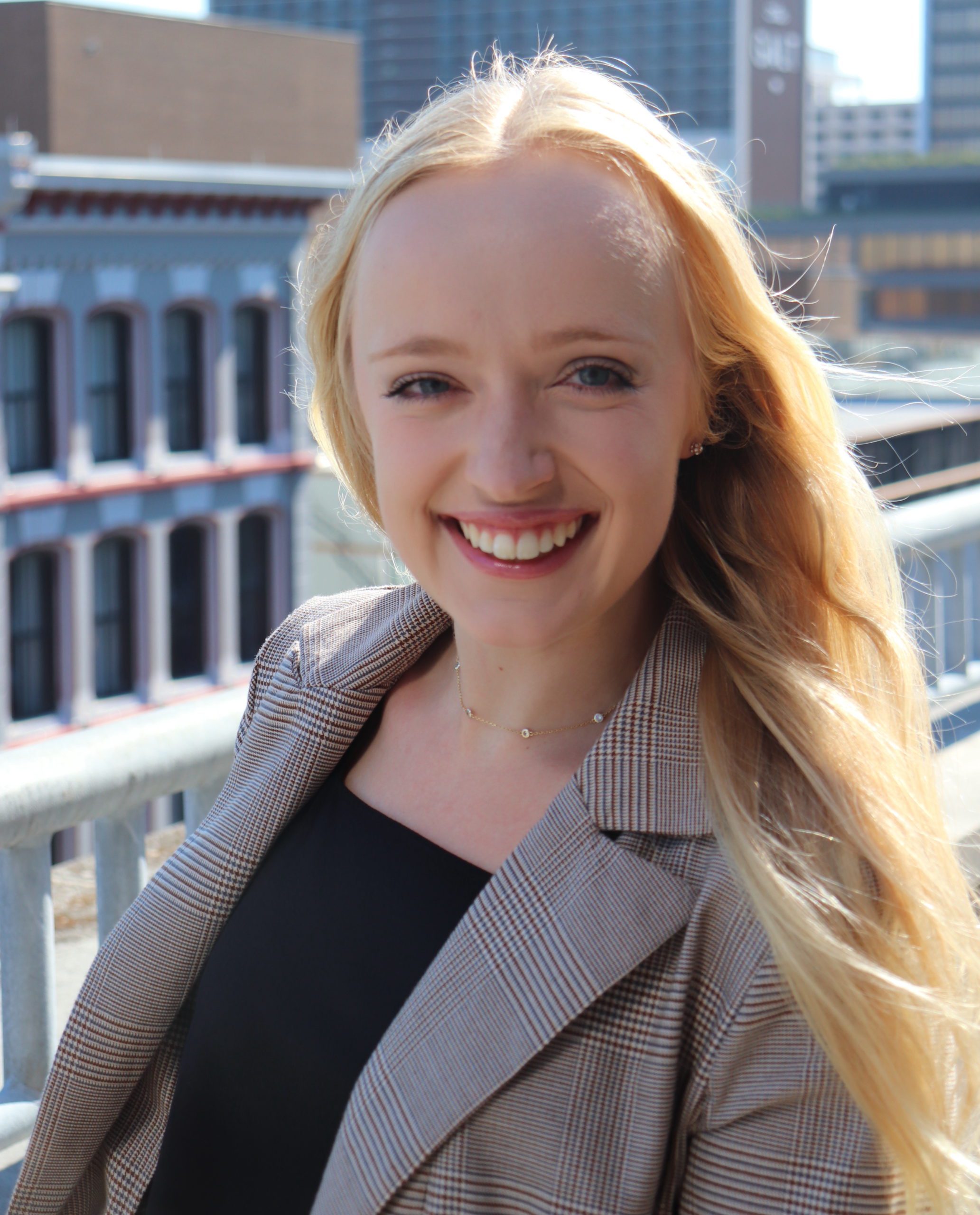 Headshot of Natalie Bonura wearing a grey suit and black shirt.